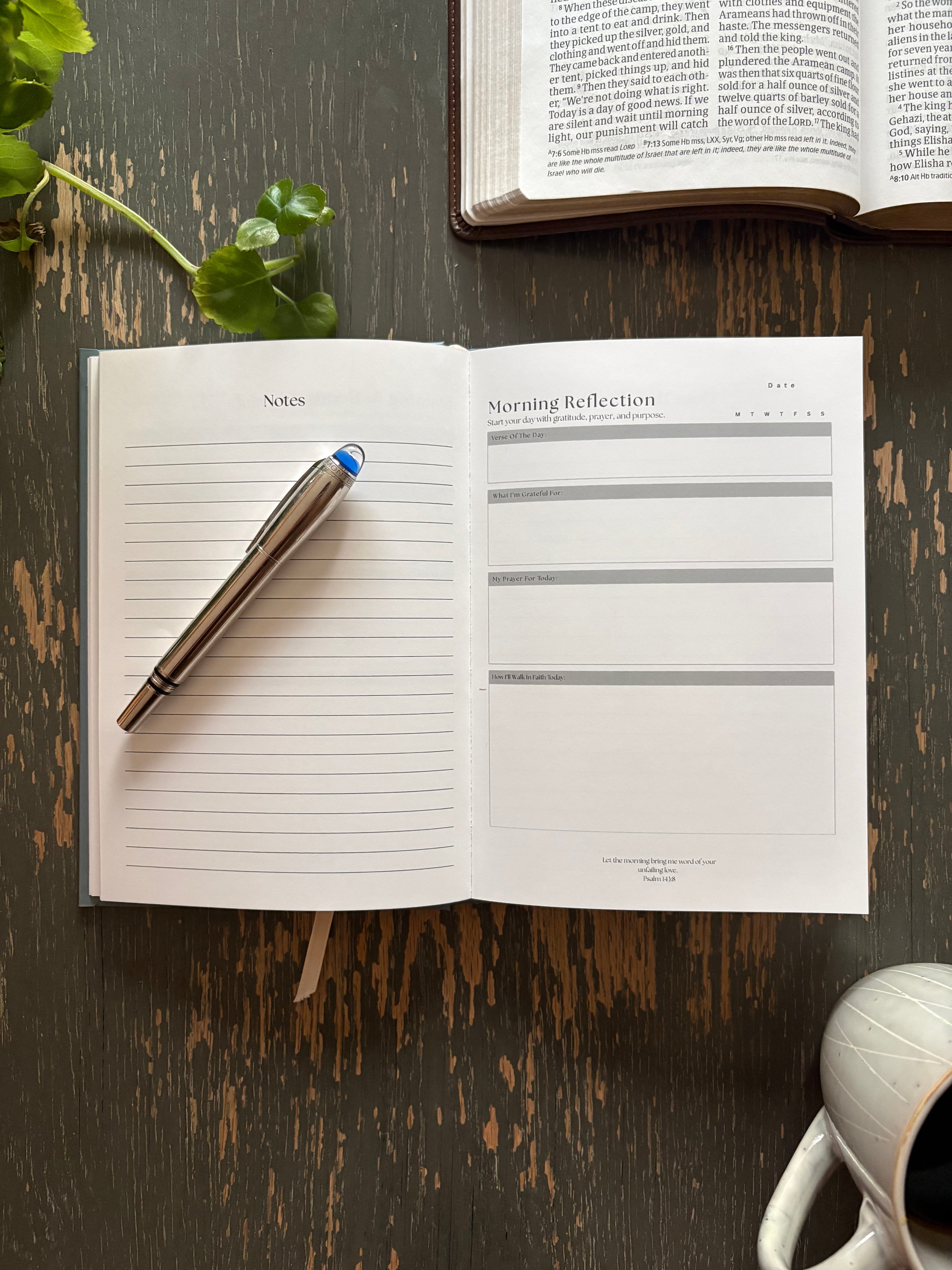 Open FaithBase Journal on a wooden table showing guided reflection pages.
